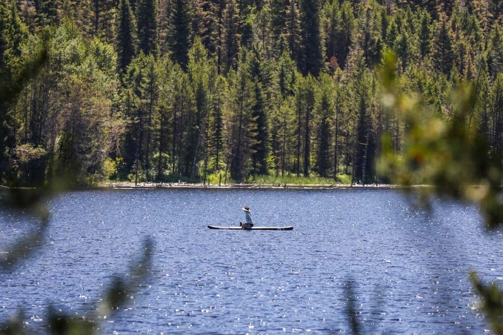 Woman kneeling on a paddle board on a lake